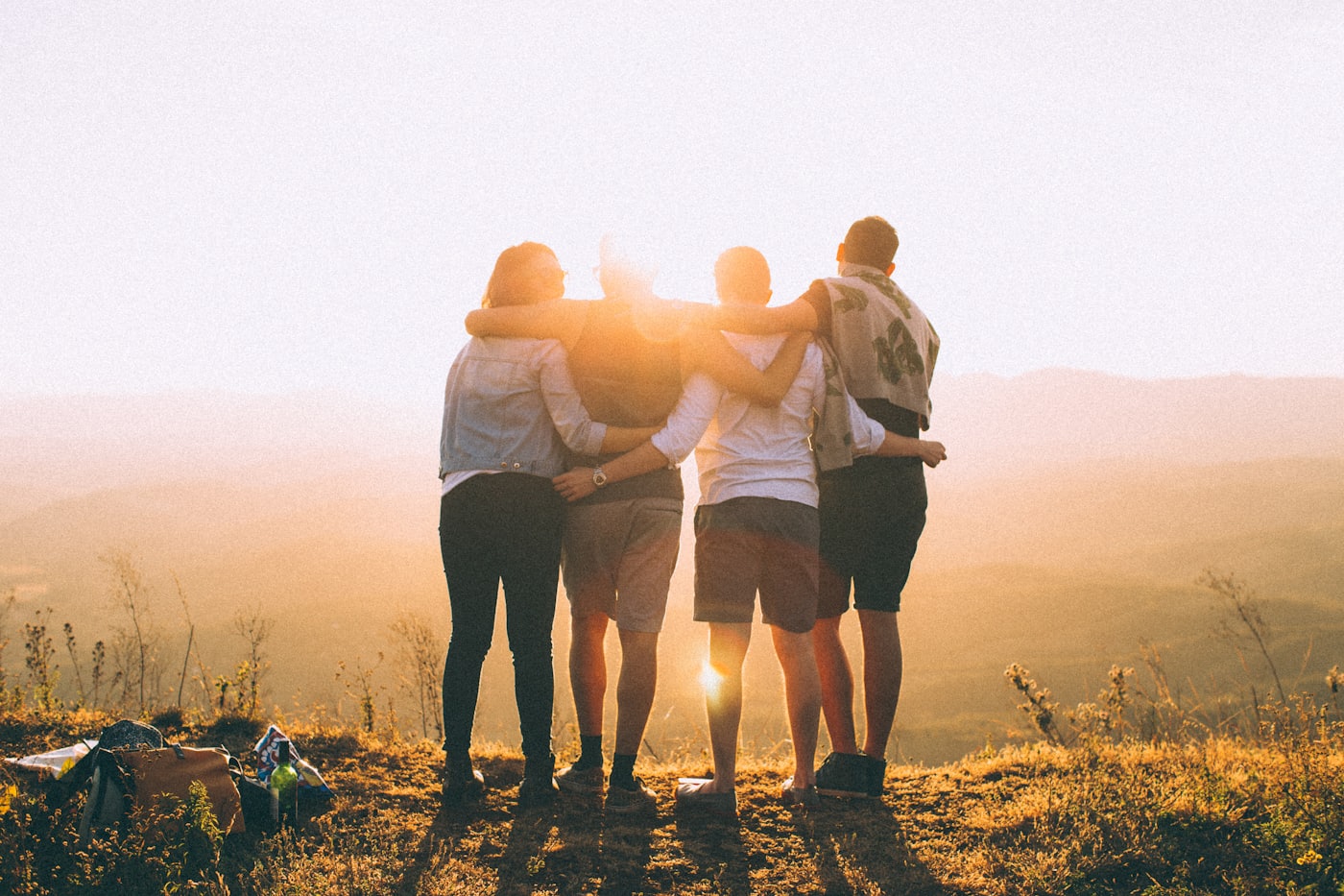 Colleagues with arms around each other, watching the sunset together